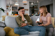 © JustLife - Husband and wife are arguing on the couch. Angry wife is yelling at her husband.