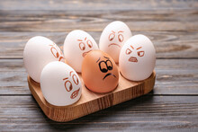 Chicken Eggs With Drawn Faces On Wooden Background. Racism Concept