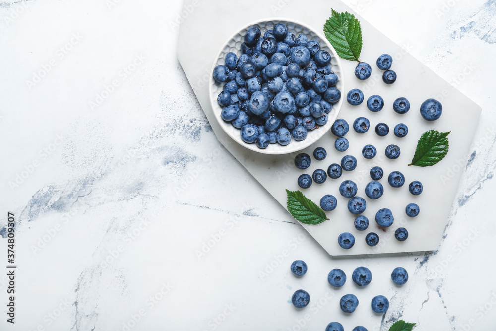Tasty blueberry in bowl on light background