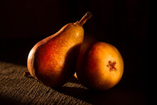 Three Pears On A Black Background In The Setting Sun. Still Life.