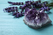 Amethyst and healing herbs on light blue wooden table, closeup