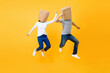 © Atstock Productions - Fun portrait of faceless anonymous couple covering heads with paper bags jumping in mid-air isolated on yellow studio background