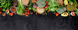 Fototapeta Kuchnia - Fresh vegetables, fruits and cereals on a black background, top view, copy space. A balanced vegetarian diet.