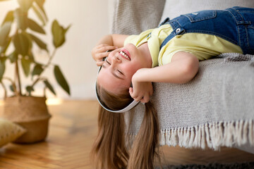 Wall Mural - Teenage girl lying upside down on couch