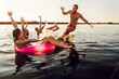 © Zoran Zeremski - Group of young friends having fun enjoying a summer day swimming and jumping at the lake.