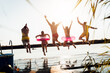 © Zoran Zeremski - Group of young friends having fun enjoying a summer day swimming and jumping at the lake.