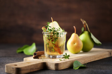 Traditional autumn spicy cocktail with pear, cider and cinnamon.  Cold fruit drink in glass