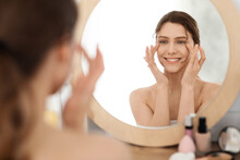 Young Woman Massaging Eye Zone, Looking At Mirror