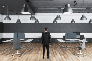 Wall Mural - Businessman standing in coworking office interior with workplace