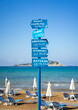 wooden blue signs on a post in a beach under blue sky