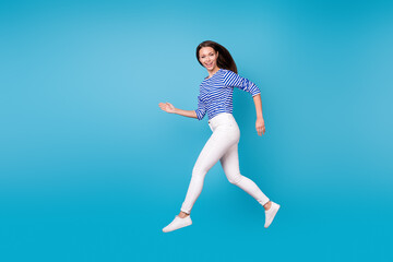 Canvas Print - Full length body size profile side view of her she nice attractive slender cheerful cheery girl jumping running going wearing casual isolated bright vivid shine vibrant blue color background