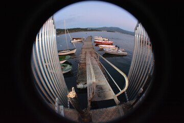 Sticker - Peephole view of a small port with boats in the water