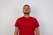 © Roquillo - Young caucasian man wearing red t-shirt over white background looking sleepy and tired, exhausted for fatigue and hangover, lazy eyes in the morning.