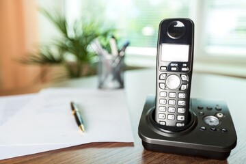 wireless telephone on a wooden desk