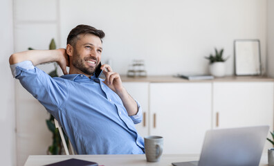 Wall Mural - Pleasant Call. Handsome man office worker talking on cellphone at workplace