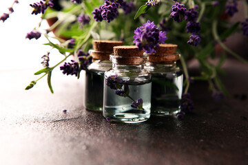 Glass bottle of Lavender essential oil with fresh lavender flowers for healthy aromatherapy spa massage concept on table