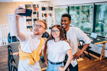 Sticker - Positive diverse coworkers smiling during selfie