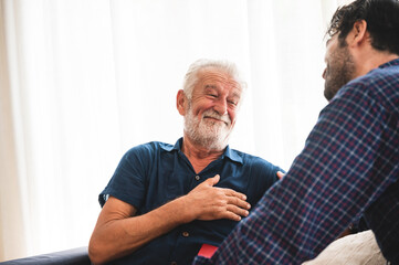 An adult hipster son and senior father living at home, talking together