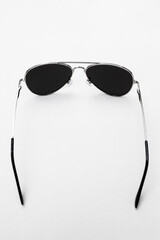 Sunglasses with metal frames on white background top view