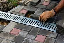 Installation Of Light Metal Grating And Gutters For Drainage Of Rainwater And Paving Slabs. Selective Focus.