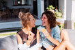 © Анастасия Каргаполов - Two happy fit woman in pink and yellow sunglasses smiling having fun laugh with donuts outside villa hotel at natural day light.
