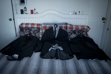 Canvas Print - High angle shot of black wedding suits on the bed