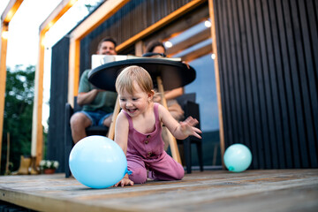 Young family with small daughter outdoors, weekend away in container house in countryside.