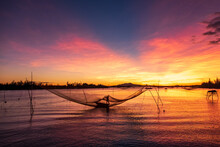 Silhouette Of A Fisherman Checking His Nets At Sunrise, Vietnam