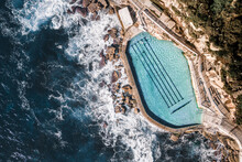 Aerial Top Down View Of Ocean Water Coastal Swimming Pool With Person Swimming In Bronte, Sydney, Australia