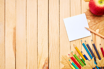 Wall Mural - back to school concept. education and study stationery on a wooden desk. above view. decorated with yellow maple leaves