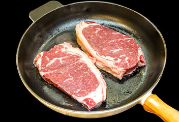 Wall Mural - Striploin steak (new York) of marbled beef is fried in a black pan