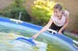 une belle fille nettoyage piscine extérieure à filet cuillère