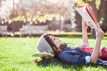 Asian College Student Studying While Lying Down On The Grass