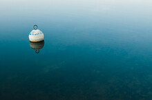 Wooden Buoy Floating On Water Surface