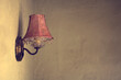 © Rachel Bellinsky/Stocksy - A lone pink vintage lamp on a textured wall