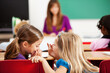 © Sean Locke Photography/Stocksy - Classroom: Girls Giggling Instead of Working