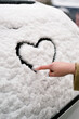 © Pixel Stories/Stocksy - Woman making heart symbol on car window