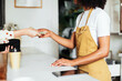 © BONNINSTUDIO/Stocksy - Crop woman paying for order in cafe