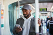 © BONNINSTUDIO/Stocksy - Black guy using smartphone in transport