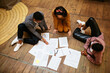 © BONNINSTUDIO/Stocksy - Creative colleagues sitting on floor and working with papers
