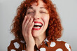 © BONNINSTUDIO/Stocksy - Redhead woman laughing in studio