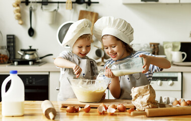 Wall Mural - Happy siblings preparing food in kitchen.