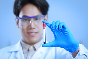 Wall Mural - Asian male scientist holding newly discover approved vaccine from laboratory in bottle with copy space