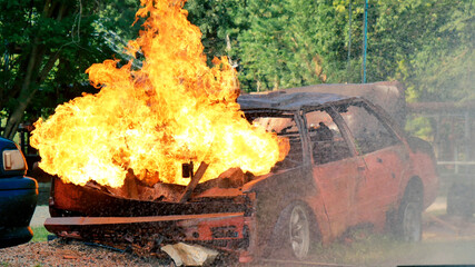 Firefighter fighting with flame using fire hose chemical water foam spray engine. Fireman wear hard hat, body safe suit uniform for protection. Rescue training in fire fighting extinguisher