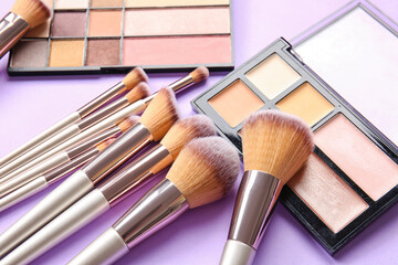 Set of makeup brushes and cosmetics on color background