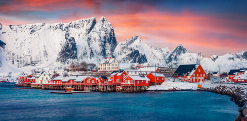 Panoramic evening view of popular tourist destination - Lofoten Islands archipelago. Colorful houses on the shore of Norwegian sea. Wonderful winter scene of Sakrisoy fishing village. 