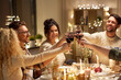 © Syda Productions - holidays, celebration and people concept - happy friends having christmas dinner party drinking non-alcoholic red wine at home