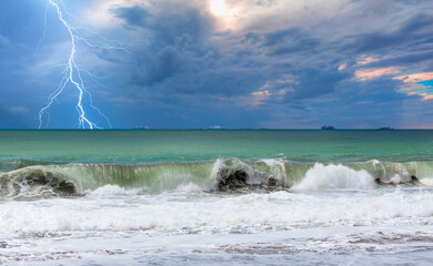 Many cargo ships waiting in the middle of the sea to unload cargo with lightning in dark sky and stormy sea 