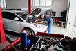 © AS Photo Family - Car repair and maintenance theme. Mechanic in uniform working in auto service, checking engine.