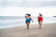 © DisobeyArt - Plus size women walking on the beach having fun during summer vacation - Curvy female laughing together - Overweight body and travel concept